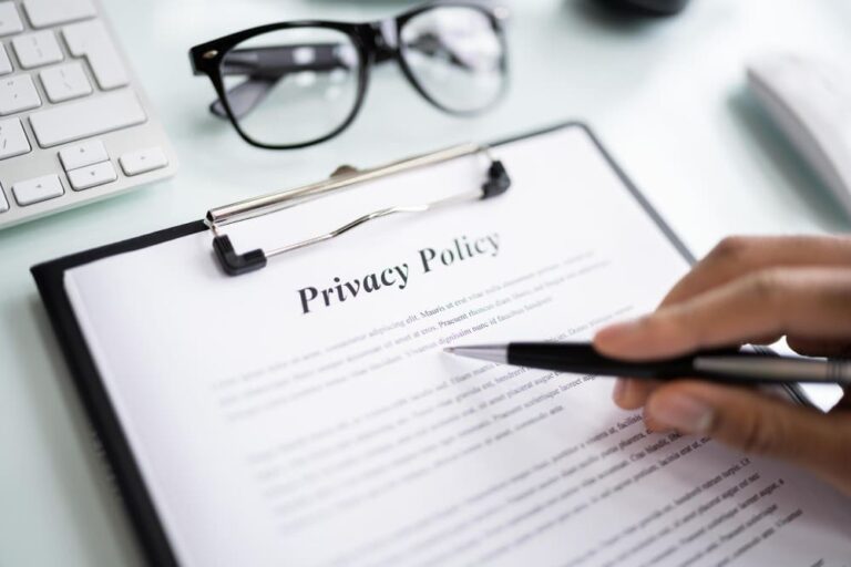 Persona che legge una politica sulla privacy con occhiali, tastiera e mouse.